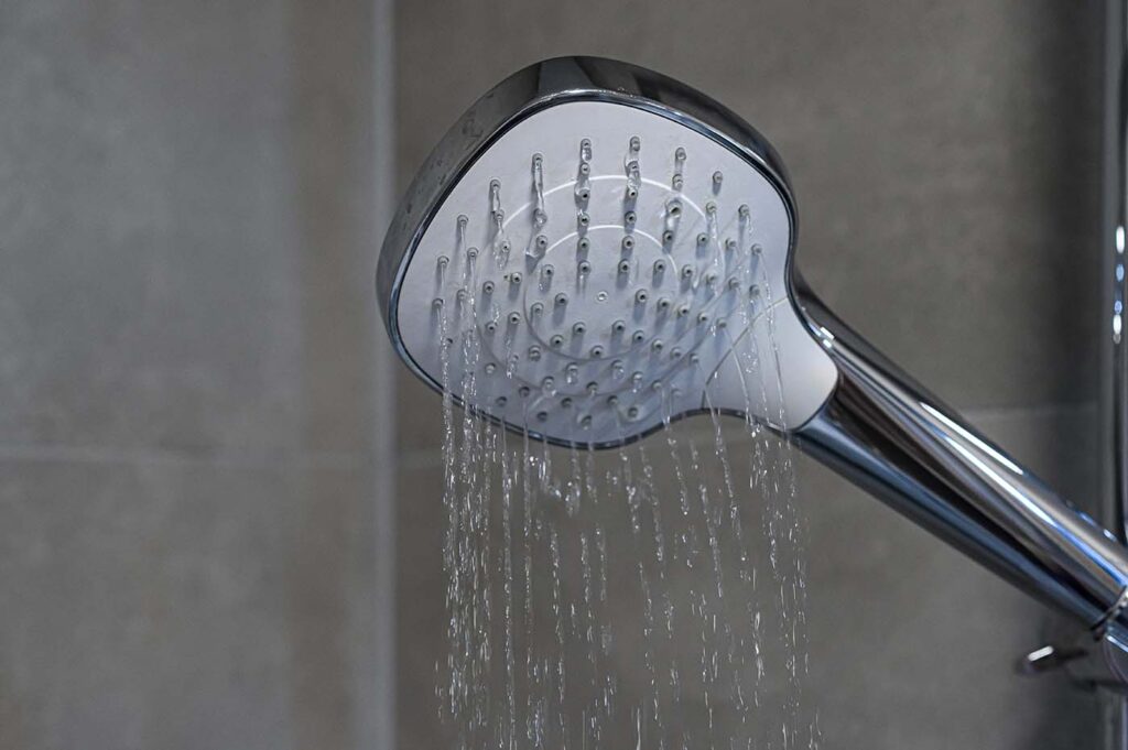 Why You Might Have Low Water Pressure - this image shows a shower head with very low water pressure