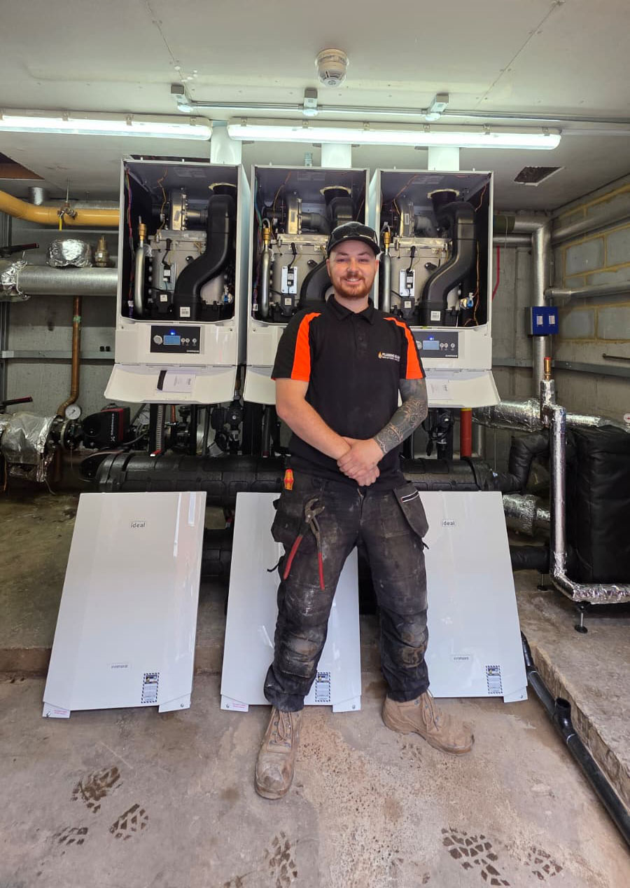 Breathing New Life into a Care Home Heating System this image shows of heating engineer Kellan in front of the 3x newly installed boilers