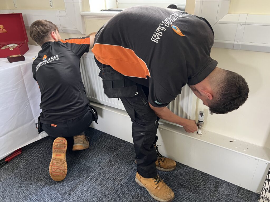 Here is an image of our plumbers installing a radiator for our client.