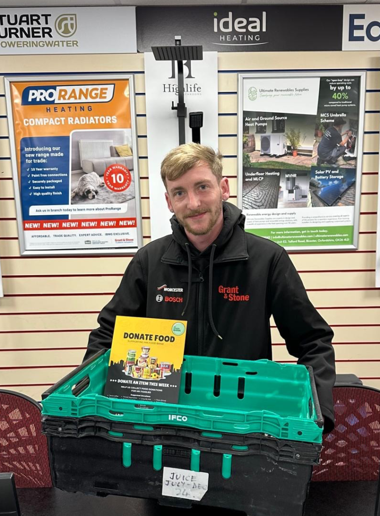 Grant & Stone showroom staff holding MK Food Bank donation crate ready to collect food donations in Milton Keynes