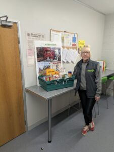 Elavation Wolverton team with filled MK Food Bank donation crate at office collection point