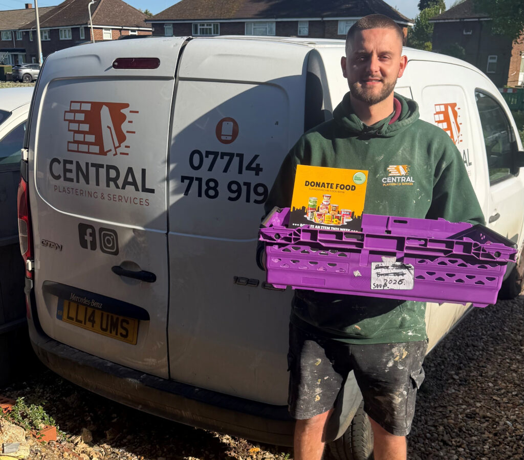 Central Plastering & Services team member holding MK Food Bank donation crate in front of company van in Milton Keynes