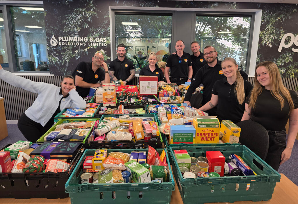 PGS Group team with MK Food Bank donations showing 1,253 items collected across Milton Keynes campaign