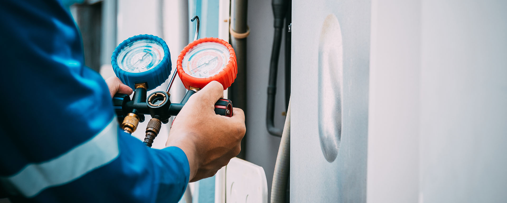 Engineer carrying out domestic air conditioning servicing and pressure checks on residential cooling system in Milton Keynes