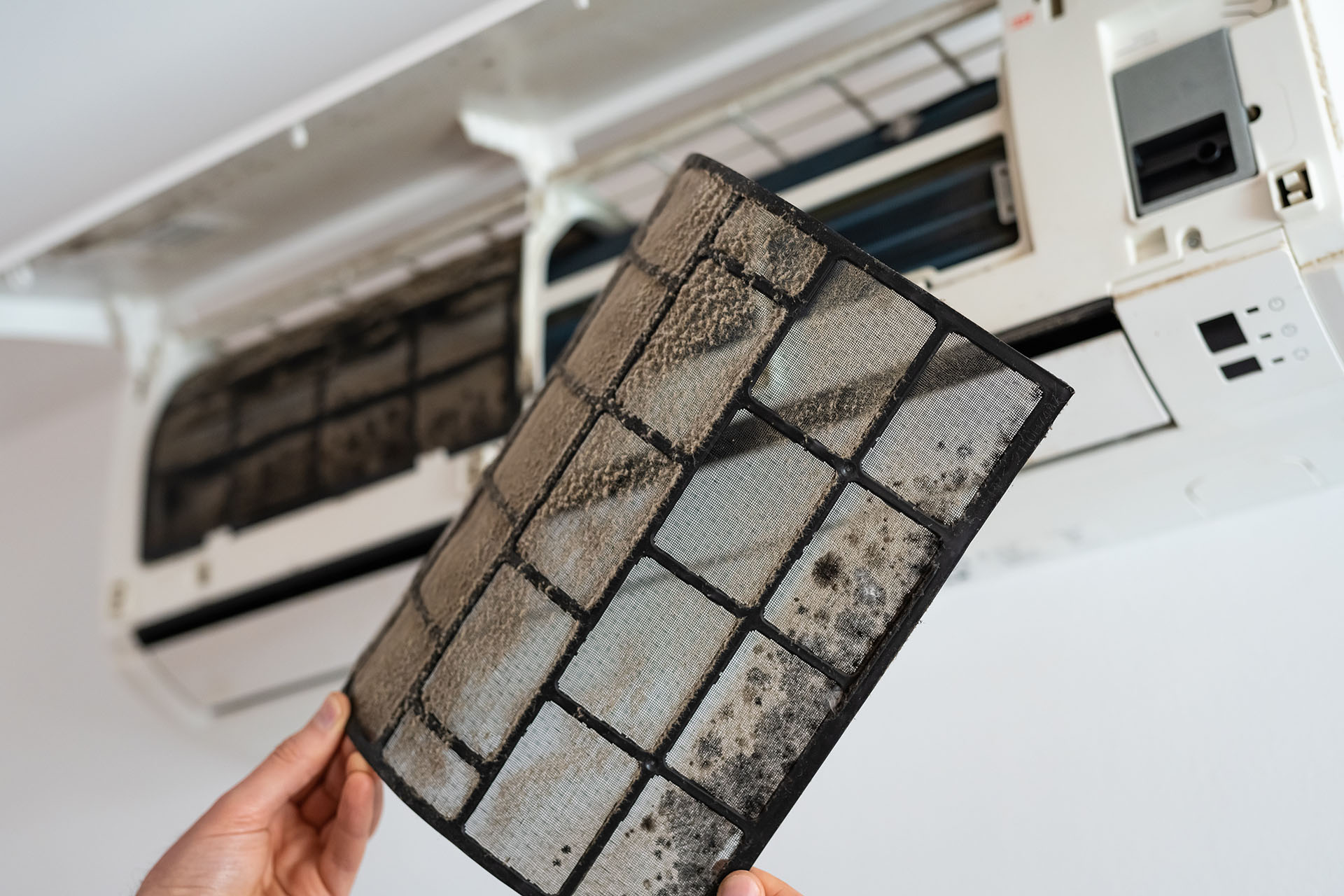 Dirty domestic air conditioning filter removed during professional servicing and maintenance inspection in Milton Keynes