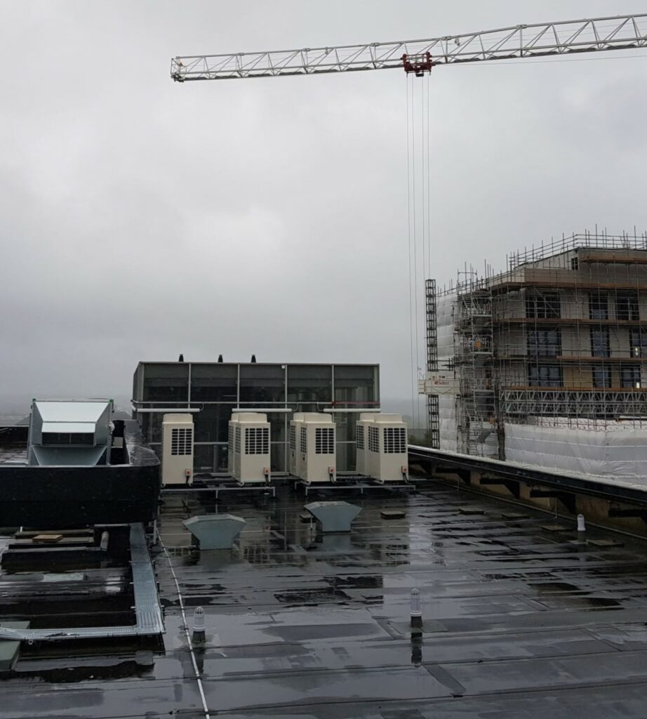 Rooftop air conditioning units beside a commercial building under construction
