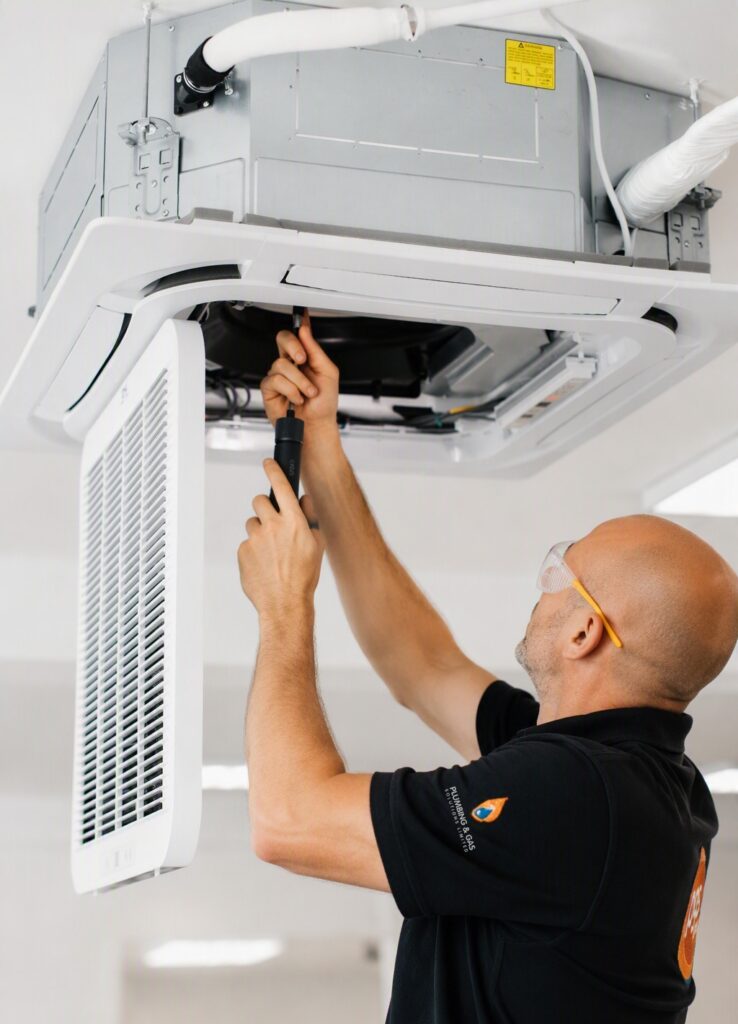 An engineer servicing a commercial air conditioning unit